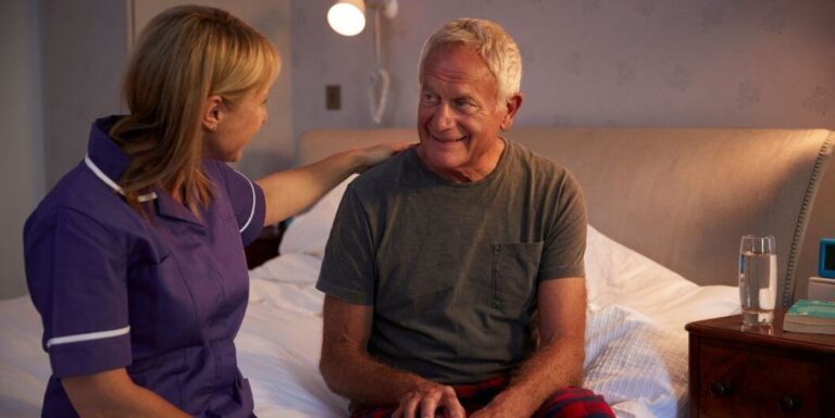 Female Nurse Comforting Elderly Man in Assisted Living Facility