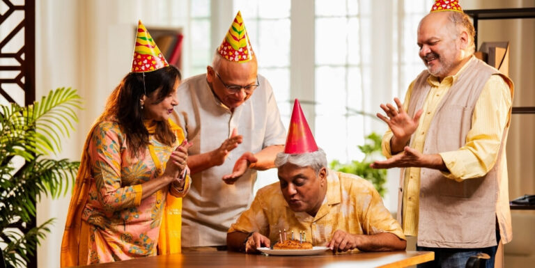Group of Elderly Residents Celebrating a Birthday with Cake at a Memory Care Facility