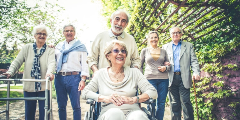 Group of Seniors with Nursing Staff Outdoors at Memory Care Facility
