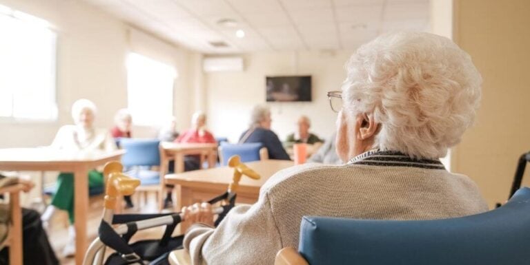 Elderly Woman Seated During Group Activity at Memory Care Facility
