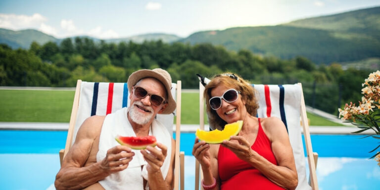 Elderly Couple Enjoying Watermelon Poolside at Memory Care Facility